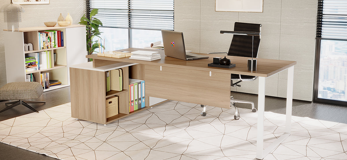 A modern office corner featuring a light-wood desk with a laptop, black desk lamp, pen cup, and books, paired with a black task chair and an open bookcase.