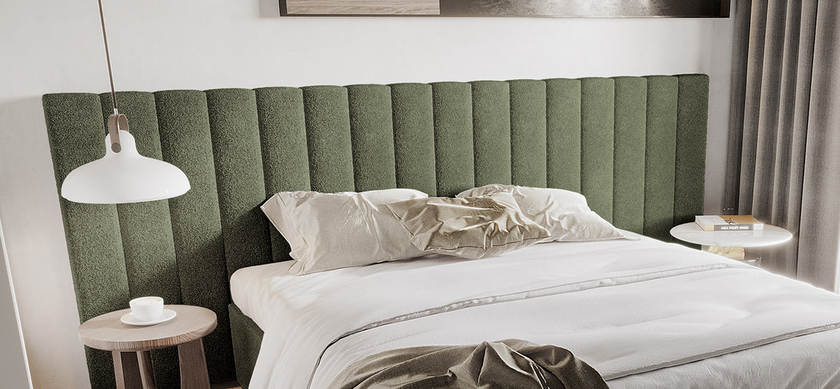 Modern bedroom with a large bed featuring a green ribbed headboard, white linens; left bedside table with coffee cup, right with books, under a pendant lamp.