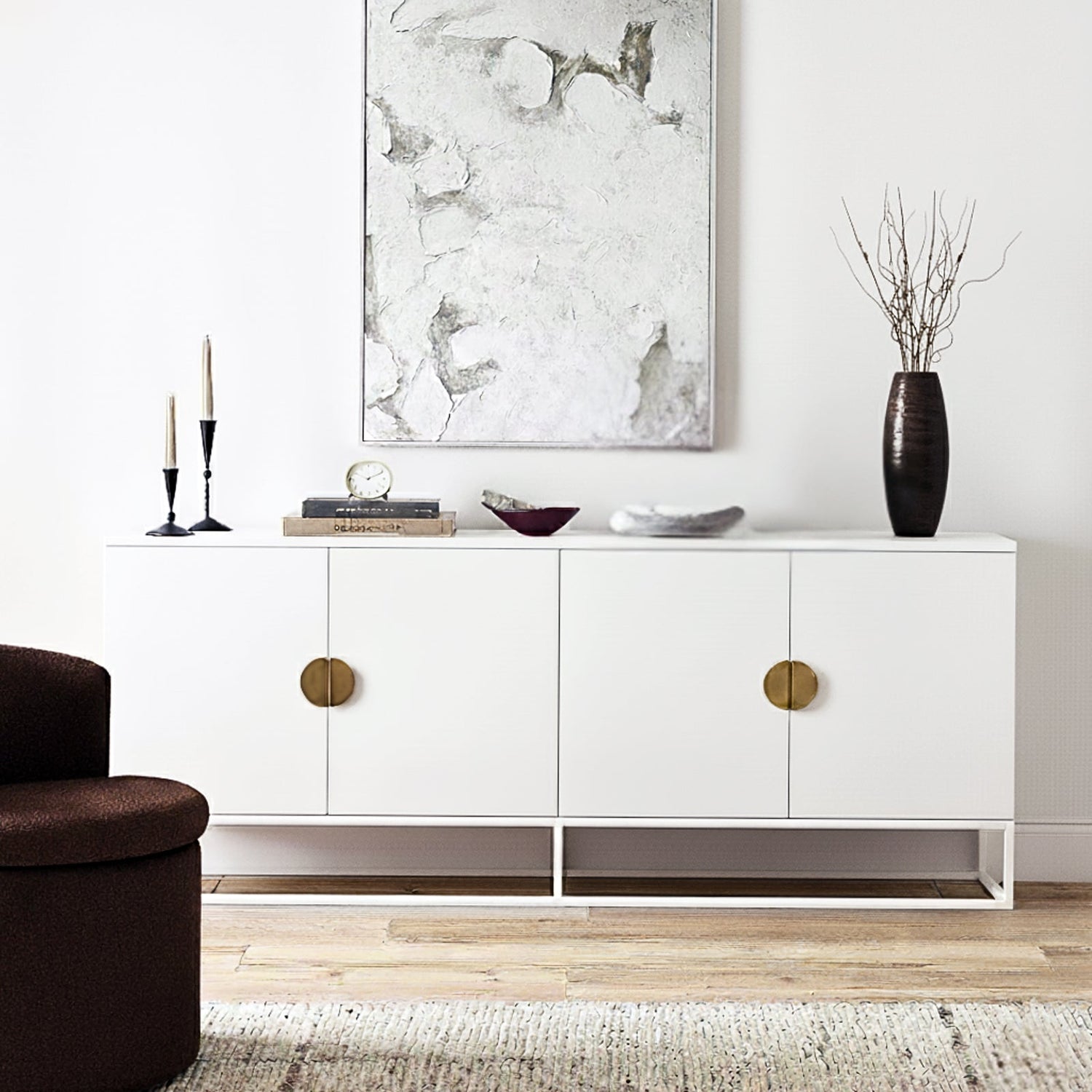 Modern white buffet sideboard with large circular gold handles and a slim metal base