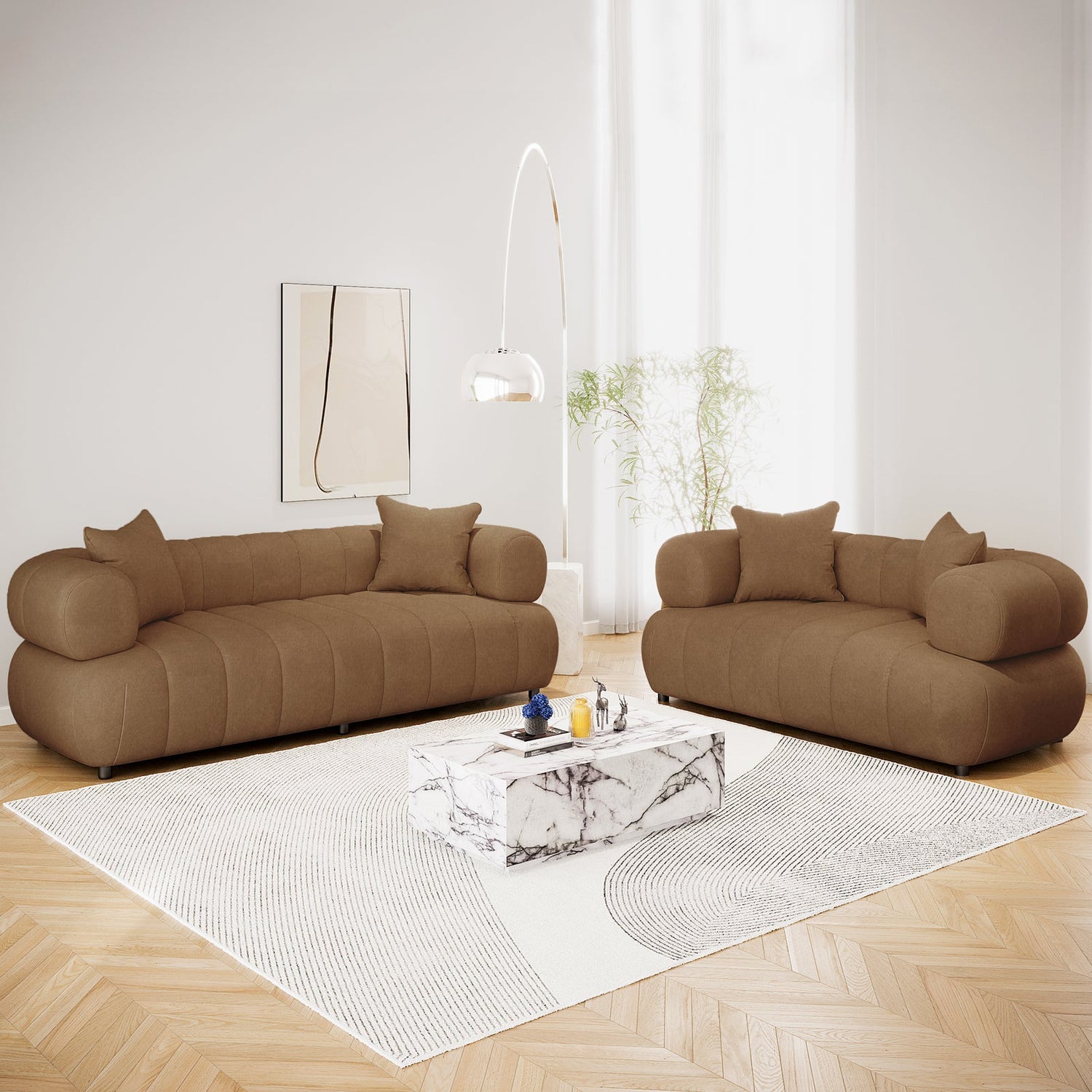 Modern living-room with deep-blue sectional sofa, glass-top coffee table, ceramic vases, area rug, white floor cushion, brass-toned floor lamp, and neutral wall art.