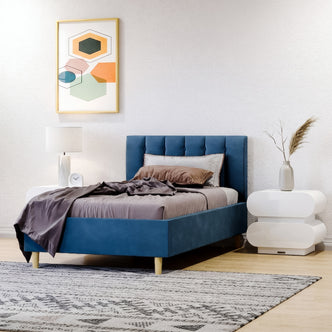 Modern guest bedroom featuring a navy blue upholstered single bed frame with a vertical channeled headboard. The room includes white sculptural 