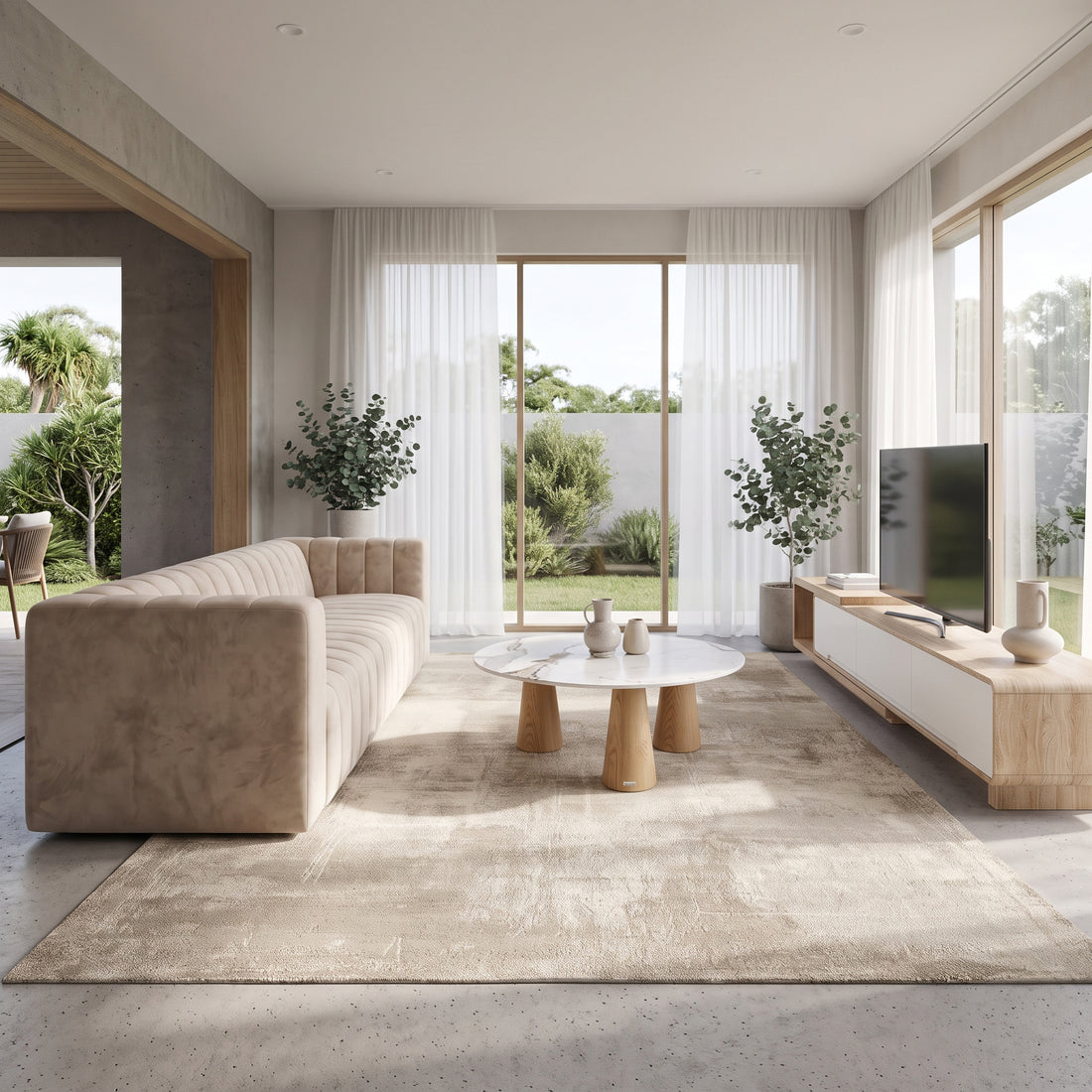 Tufted velvet sofa paired with a marble coffee table and a wooden entertainment unit in a modern open-plan living room.