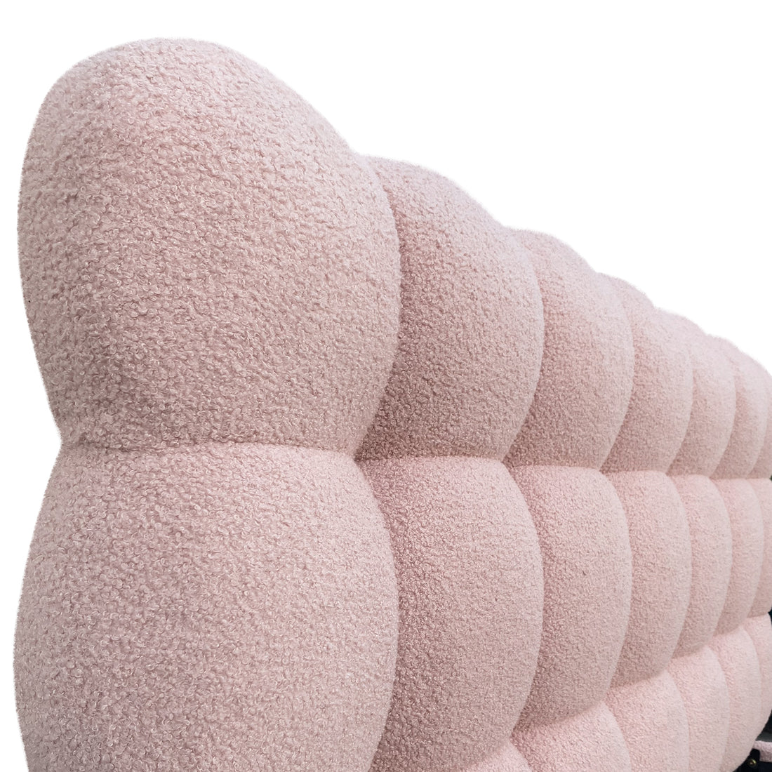 Aina Queen Bouclé Bed Frame in Pink features a close-up of its padded, tufted headboard with rounded bubble cushions in soft pink bouclé fabric, exuding modern elegance and plush comfort.