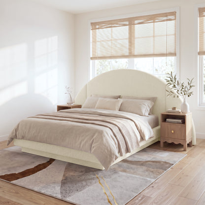 A modern neutral bedroom featuring  Cosy Bouclé Bed Frame, flanked by wooden nightstands on an abstract area rug.