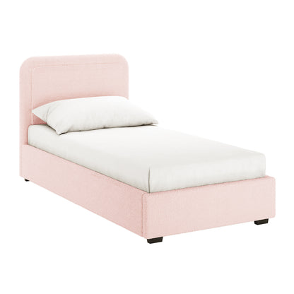 Carya Kids Single Fabric Bouclé Bed Frame in Light Pink, featuring a blush-pink bouclé-covered frame with a low profile and rounded headboard, complete with white bedding and dark block feet.
