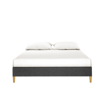 Celina Boucle Upholstered Fabric Bed Base - Black Queen features a low, modern platform with wooden legs, upholstered in luxurious boucle fabric, paired with white bedding and pillows, exuding elegance and sophistication.