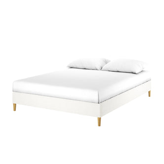 Celina Queen Boucle Fabric Bed Base in Cream White features a modern low rectangular platform with white upholstered frame, wooden legs, a white mattress, and two pillows, exuding luxury and comfort.
