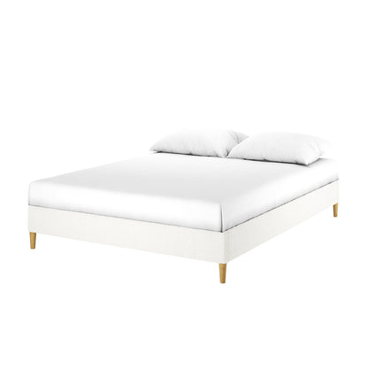 Celina Queen Boucle Fabric Bed Base in Cream White features a modern low rectangular platform with white upholstered frame, wooden legs, a white mattress, and two pillows, exuding luxury and comfort.