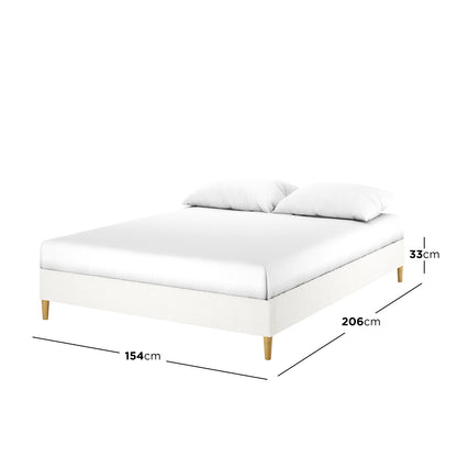 Celina Queen Boucle Fabric Bed Base in Cream White, featuring a minimalist design with white upholstery, wooden legs, and a mattress with pillows. Dimensions: 154 cm wide, 206 cm long, 33 cm high.