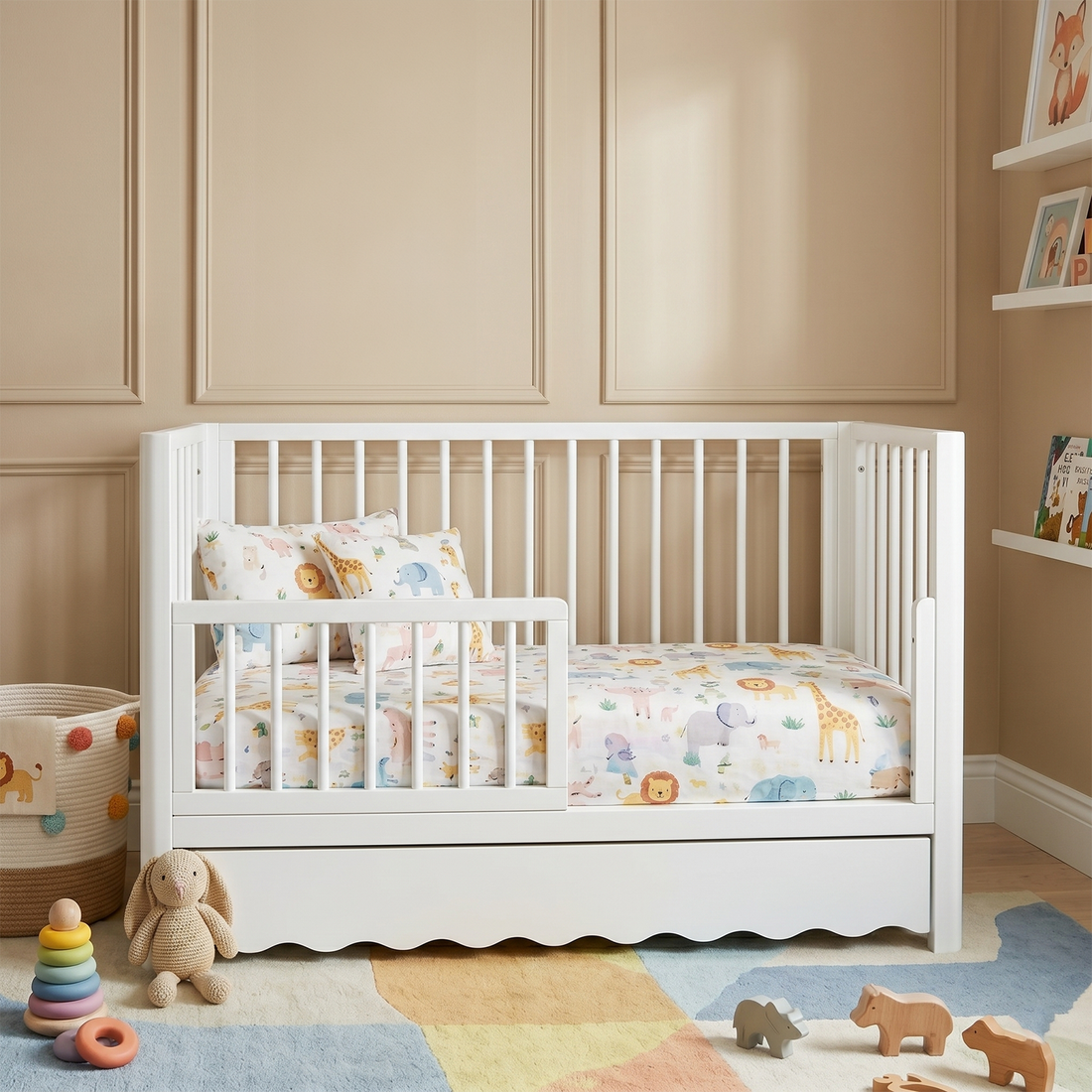 Convertible white wooden kids bed featuring a low safety rail and animal-print nursery bedding.