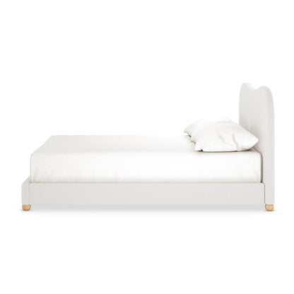 Ginnie Bouclé Curved Double Bed Frame in cream white, featuring a plush, gently curved headboard, white upholstery, and small round wooden feet, viewed from the side with pillows atop the mattress.