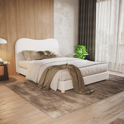 Ginnie Boucle Bed & Oriona Mattress - Double Cream, showcasing a plush curved headboard and sleek design, with a person relaxing on it, highlighting the bed's comfort and modern aesthetic.
