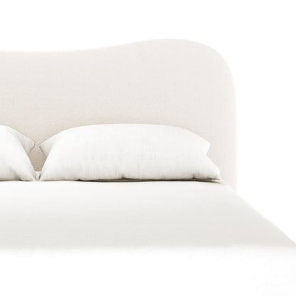 Close-up of the Ginnie Boucle Bed & Oriona Mattress - Queen Cream, highlighting the plush curved headboard and luxurious bouclé fabric, with an inviting, modern design seen in the detailed cushion texture.