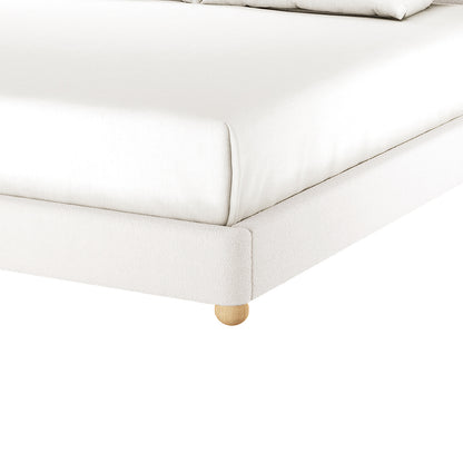 Ginnie Curved Bouclé Bed Frame - Cream White Super King shown with white-upholstered frame on wooden bun leg, fitted sheet, and visible pillows, highlighting its modern, comfortable design against a white backdrop.