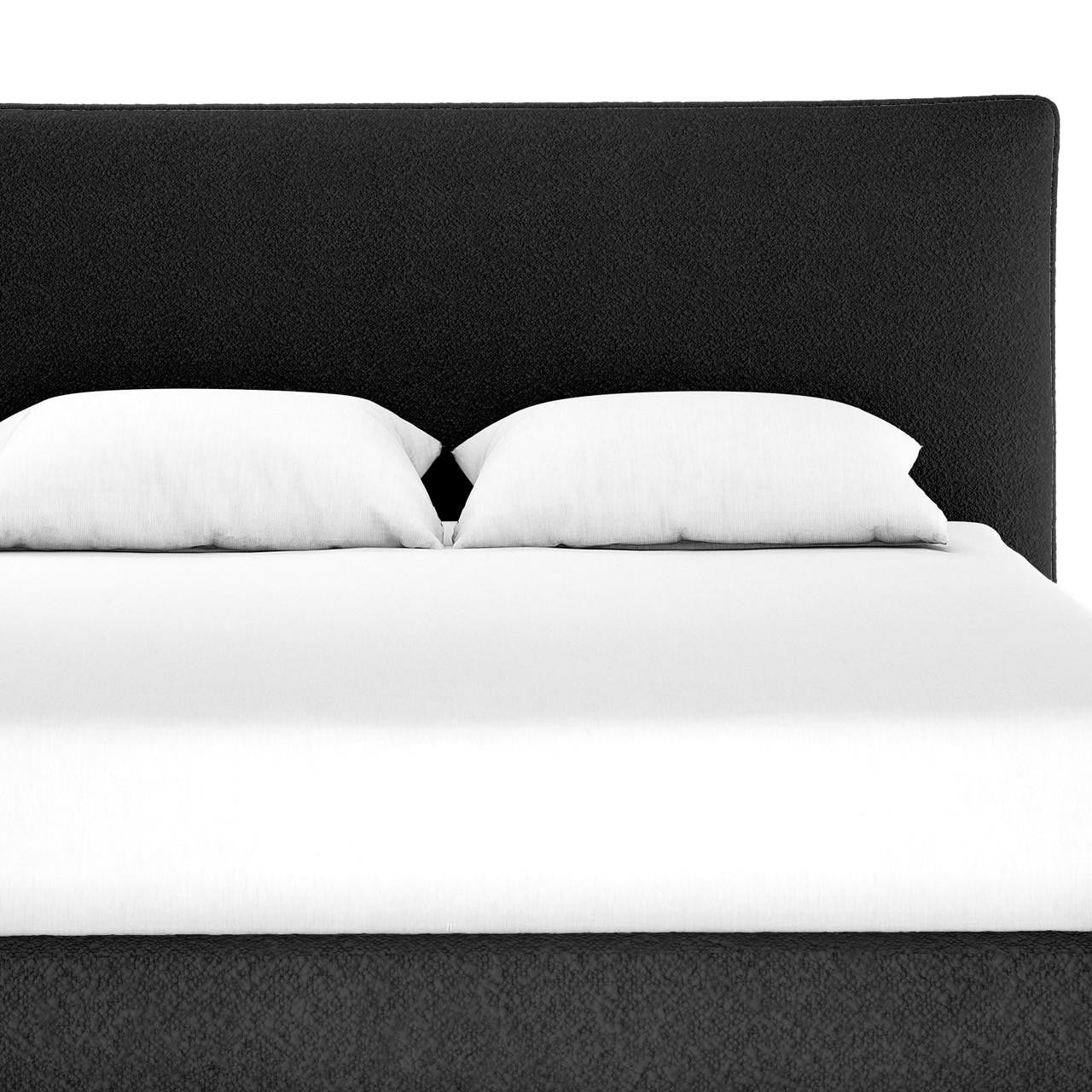 Havvan Queen Bouclé Upholstered Fabric Bed Frame - Black, featuring a plush foam-padded headboard and solid wood base, elegantly dressed in crisp white bedding with two pillows.