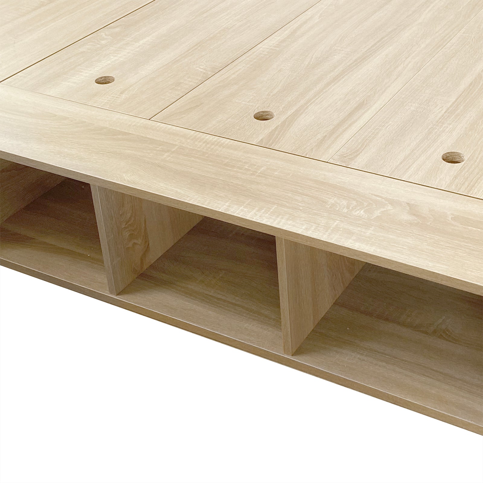 Herais Single Platform Bed Base with Storage in Oak, featuring a minimalist design with three open cubby compartments and top surface cutouts for cable management or panel lifting, ideal for organizing essentials.