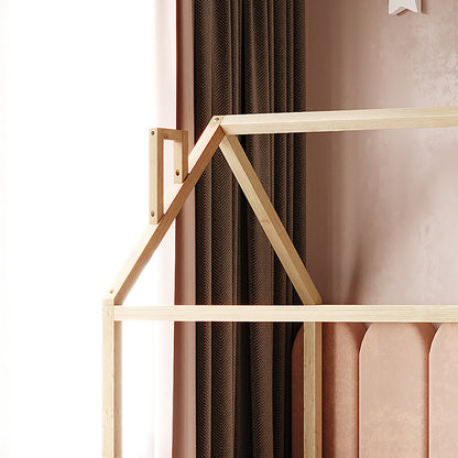 Jesse Kids Single Solid Pine Wood House Bed Frame in White; minimalist design with light wooden posts and beams forming a gabled-roof outline, set against a blush-pink wall and dark drapery.