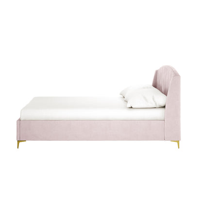 Lyra Velvet Bed Frame with Winged Headboard - Soft Pink Double, featuring blush velvet upholstery, gently curved channel-tufted headboard, white mattress, pillow, and slender gold-tone legs.