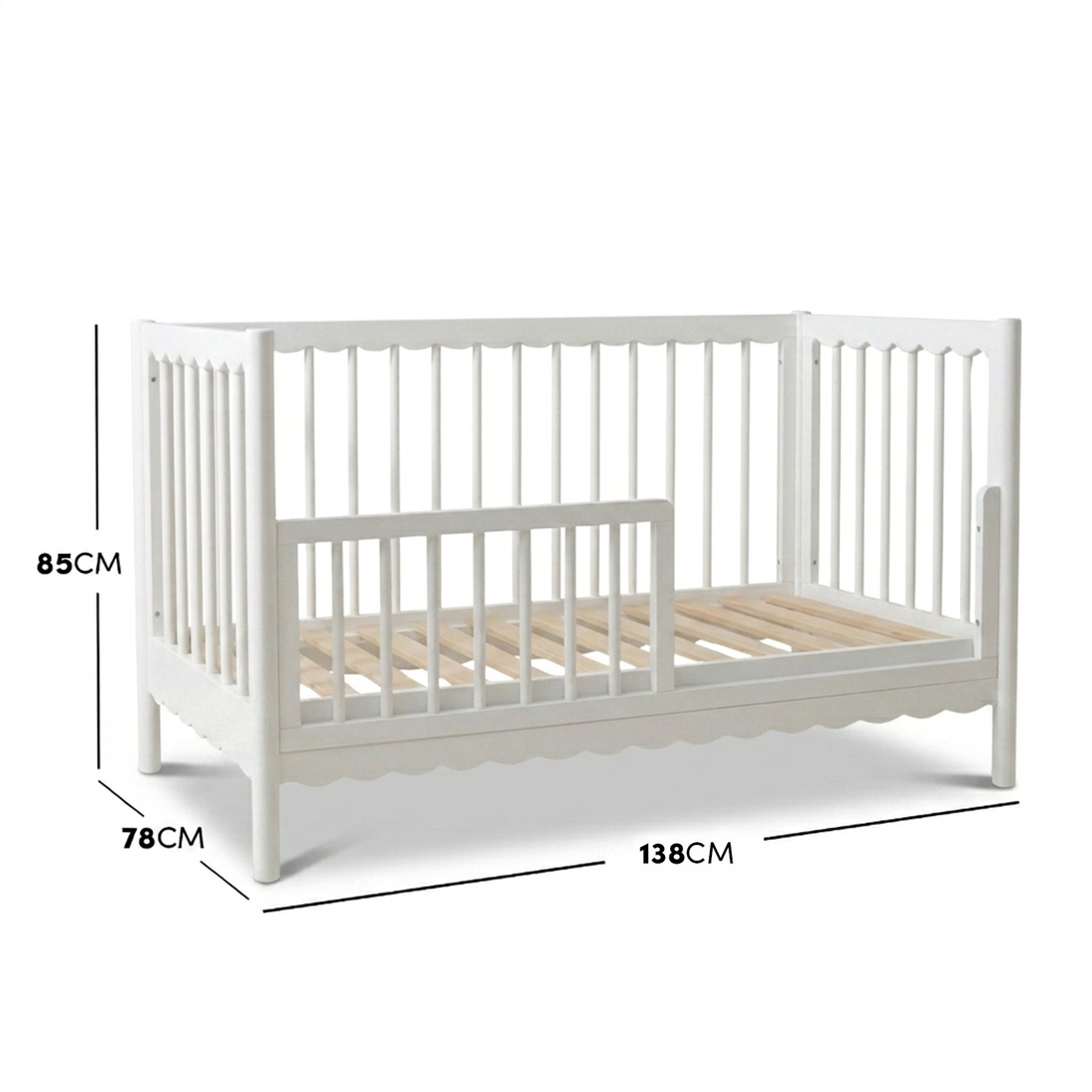 White timber toddler bed with scalloped base molding and dimensions diagram.