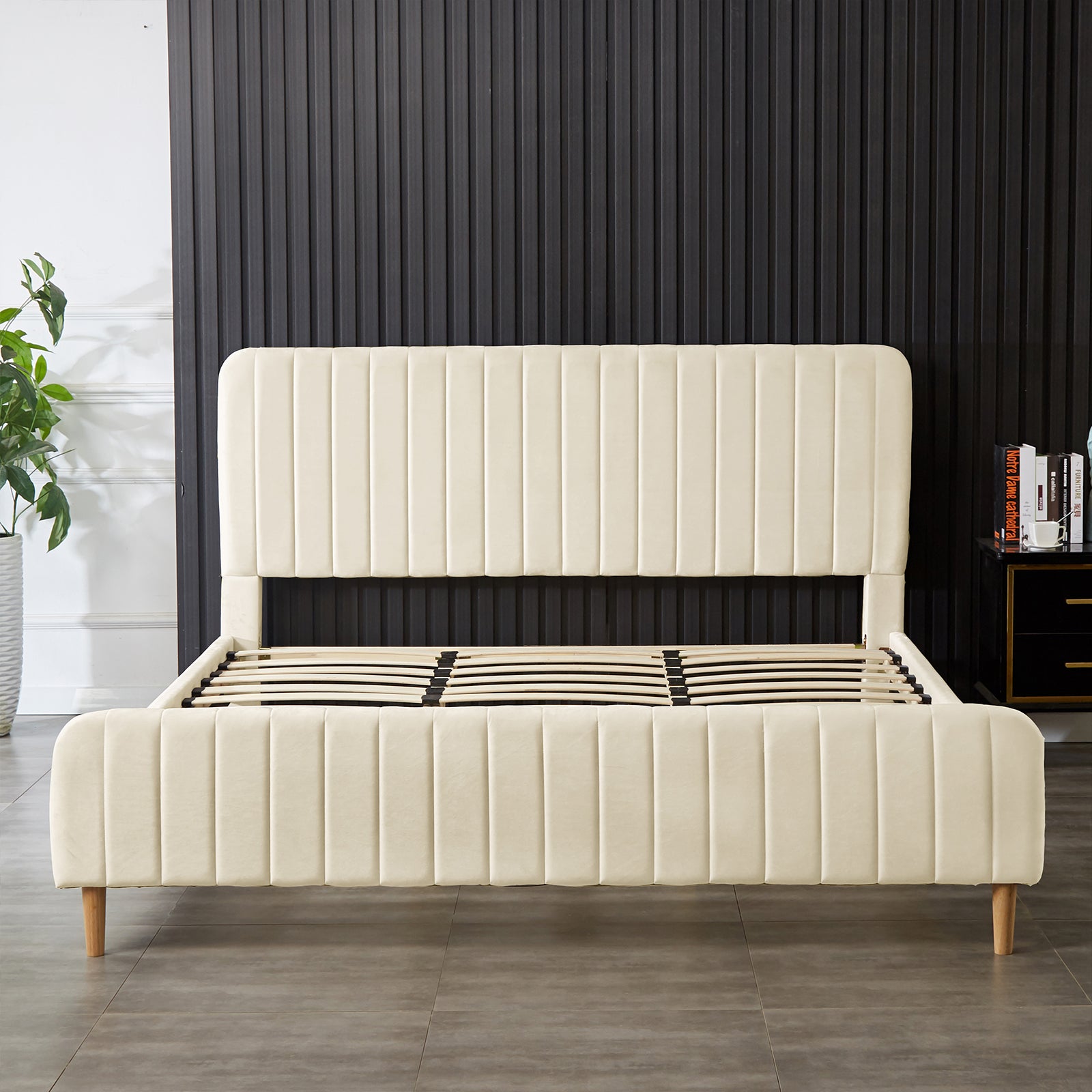 Seneca King Upholstered Velvet Bed – Sandy White features a light-beige, channel-tufted headboard and footboard on a sturdy wooden frame with tapered legs, highlighting luxury and durability.