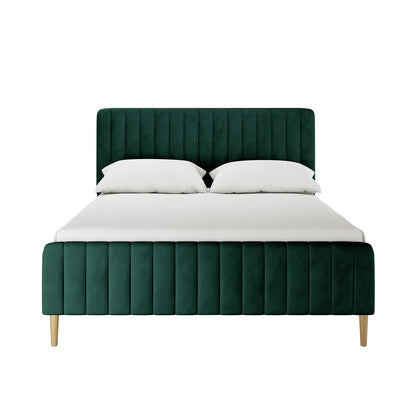 Seneca Double Upholstered Velvet Bed – Green features a forest-green velvet frame with vertically channel-tufted headboard and footboard, supported by light wood legs, dressed in white bedding, against a plain backdrop.