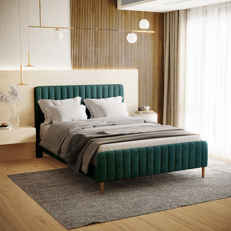 Seneca Double Upholstered Velvet Bed – Green features a rich forest-green velvet platform with channel-tufted headboard and footboard, set in a modern bedroom with neutral tones and contemporary lighting.