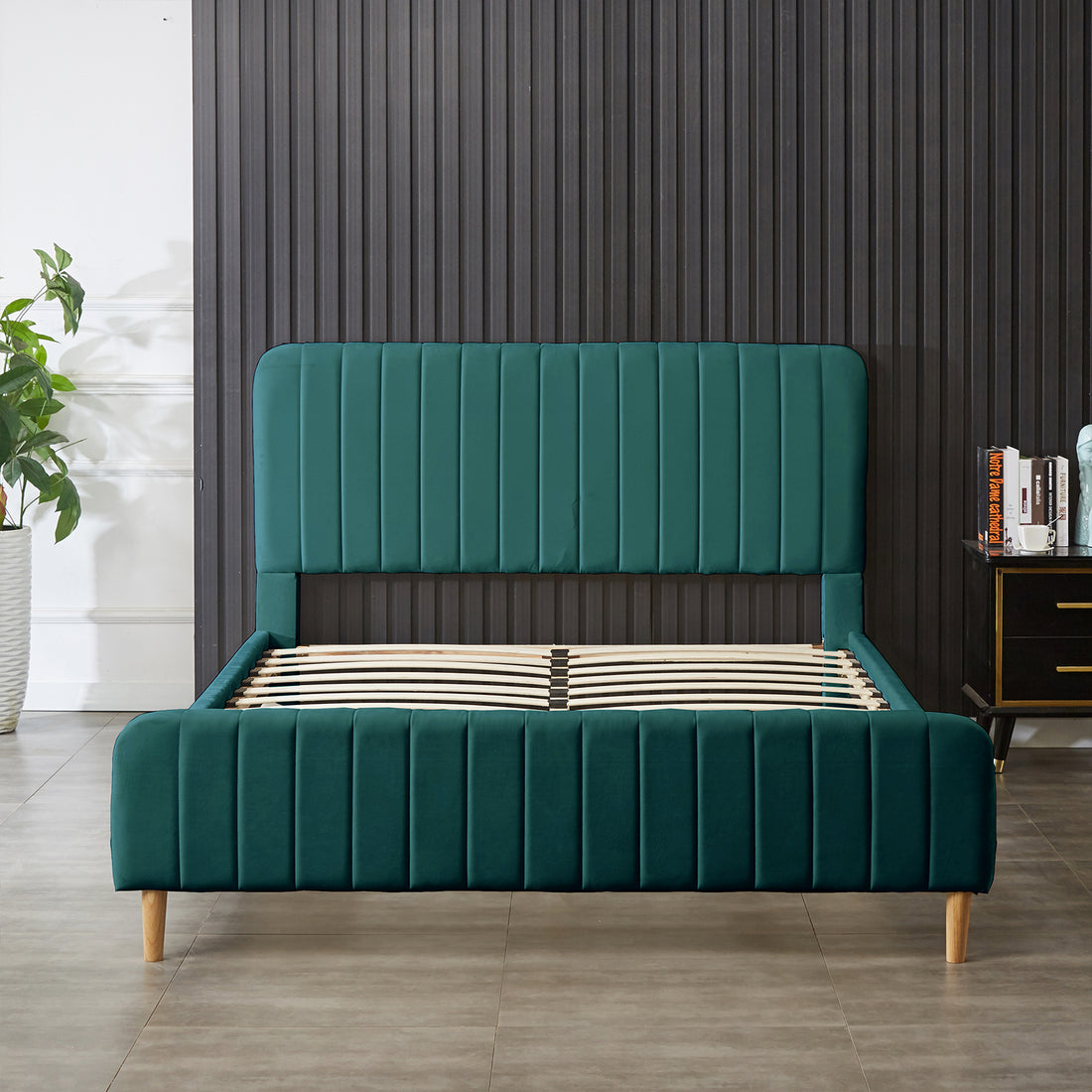 Seneca Upholstered Velvet Bed – Green, featuring a deep green velvet-like fabric, vertically-stitched headboard, matching footboard, light-wooden legs, and curved wooden slats for support, embodying luxury and modern elegance.