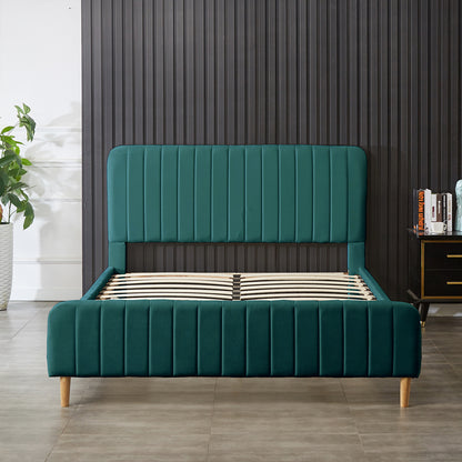 Seneca Upholstered Velvet Bed – Green, featuring a deep green velvet-like fabric, vertically-stitched headboard, matching footboard, light-wooden legs, and curved wooden slats for support, embodying luxury and modern elegance.
