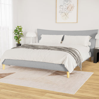 Estilla Boucle Upholstered Rainbow Single Bed - Cream White, featuring a low-profile, light-gray frame on wooden legs, adorned with crisp white bedding and a folded gray throw, complements the minimalist bedroom design.
