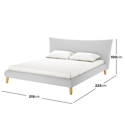 Estilla Boucle Upholstered Rainbow Single Bed - Cream White features a low-profile frame in light grey bouclé fabric, with a padded, flared headboard and four natural-finished wooden legs. Two pillows rest on the mattress.