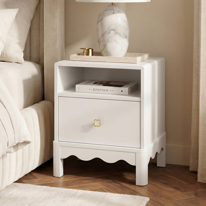 White nightstand styled with lamp and books beside bed in a cozy bedroom