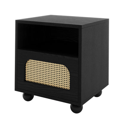 Dialga 45cm Rattan Bedside Table with Storage features a black-stained wood frame, open cubby, and a natural rattan-inlaid drawer, resting on ball-shaped feet, offering modern elegance and functionality.