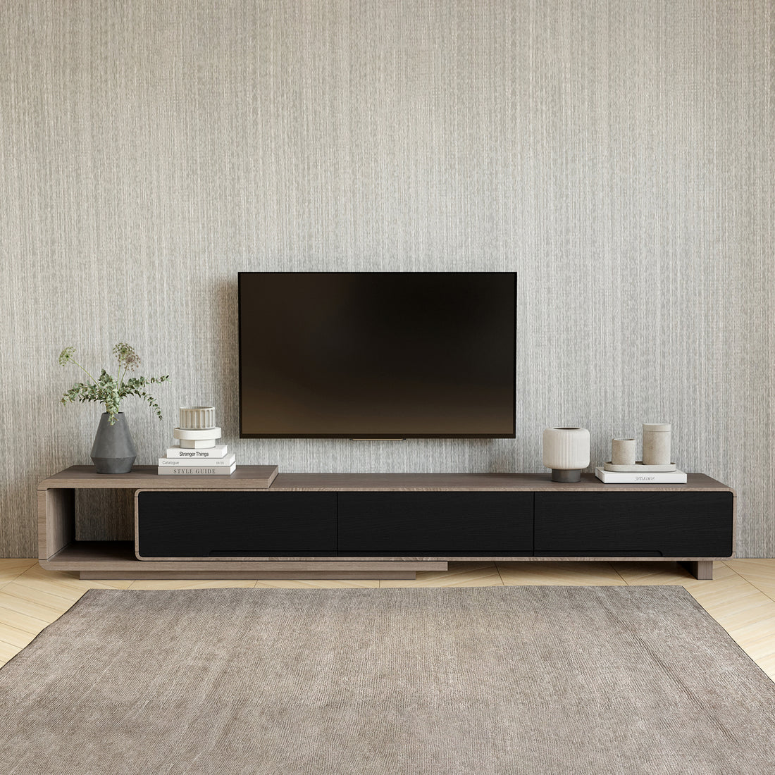 Galya Extendable Storage TV Unit - Teak features matte-black drawer fronts, rich wood grain, and ample storage with three drawers and an open shelf, complemented by modern decor elements.