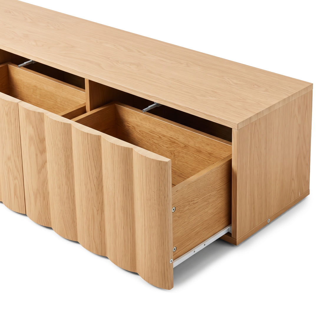 Oak TV unit with open fluted pull-out drawers revealing interior storage tracks and wood grain finish against a plain white studio background.