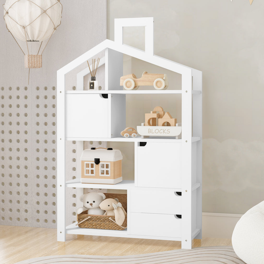 Quinta Shelf Unit with Storage White in a children’s room, featuring open shelves with toys, blocks, and a plush teddy; includes hidden cabinets and drawers for organized storage.