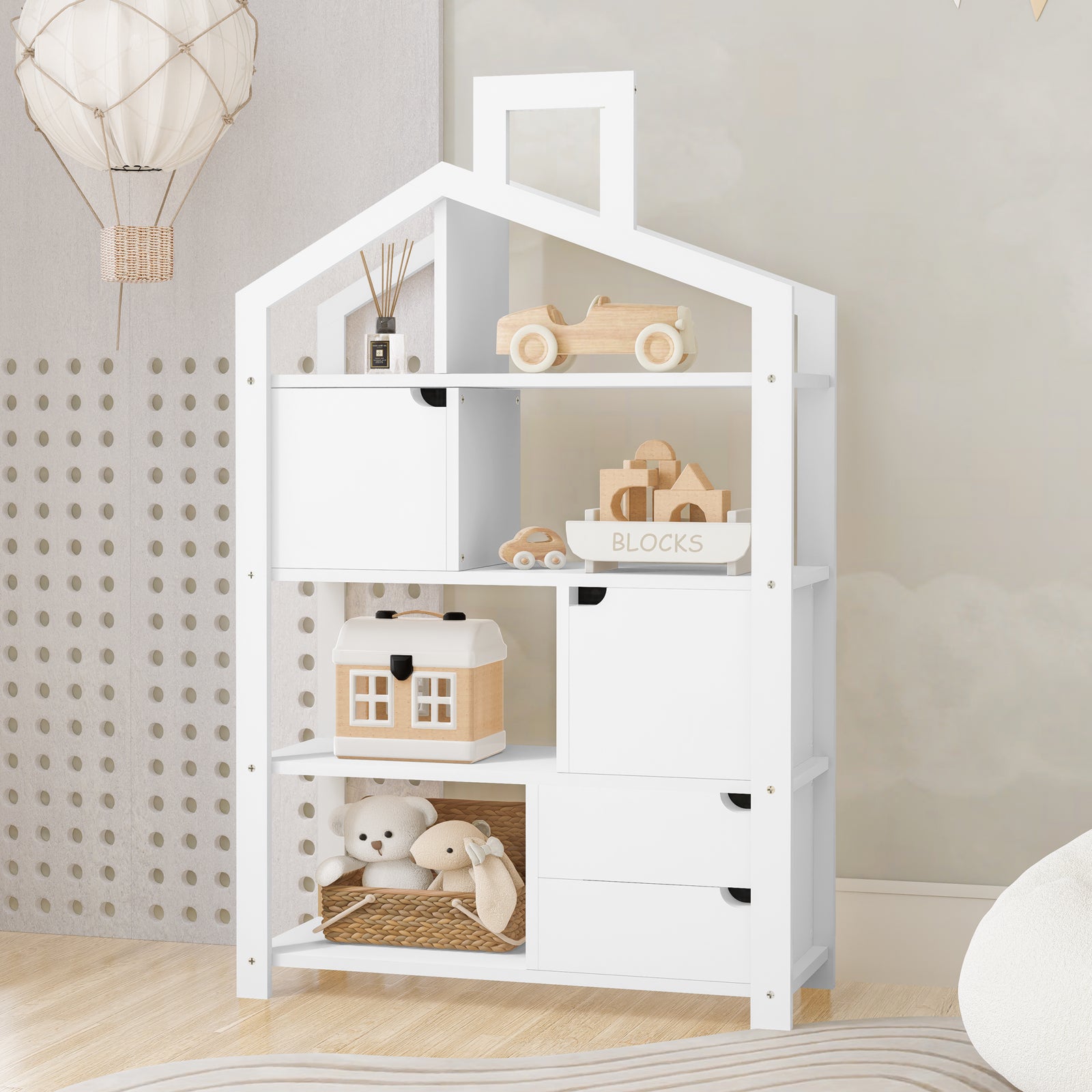 Quinta Shelf Unit with Storage White in a children’s room, featuring open shelves with toys, blocks, and a plush teddy; includes hidden cabinets and drawers for organized storage.