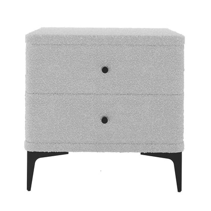 Shona Upholstered Boucle Bedside Table in Grey features a modern design with two drawers, round black pulls, and slender black metal legs, fully upholstered in boucle fabric for an elegant touch.