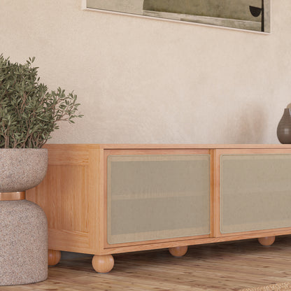 Thea 200cm Solid Oak Rattan Entertainment Unit - Natural features visible rattan sliding doors, sturdy timber legs, and ample storage with three cabinets, embodying elegant design and practical storage.