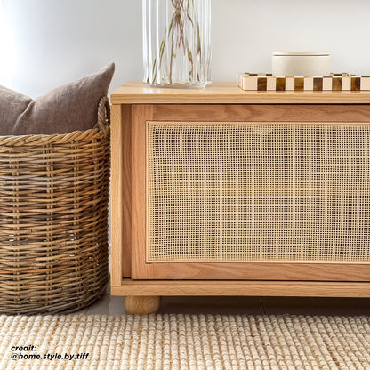 The Thea 200cm Solid Oak Rattan Entertainment Unit - Natural features elegant natural rattan sliding doors, sturdy timber legs, and ample storage, showcasing a blend of practicality and refined design.