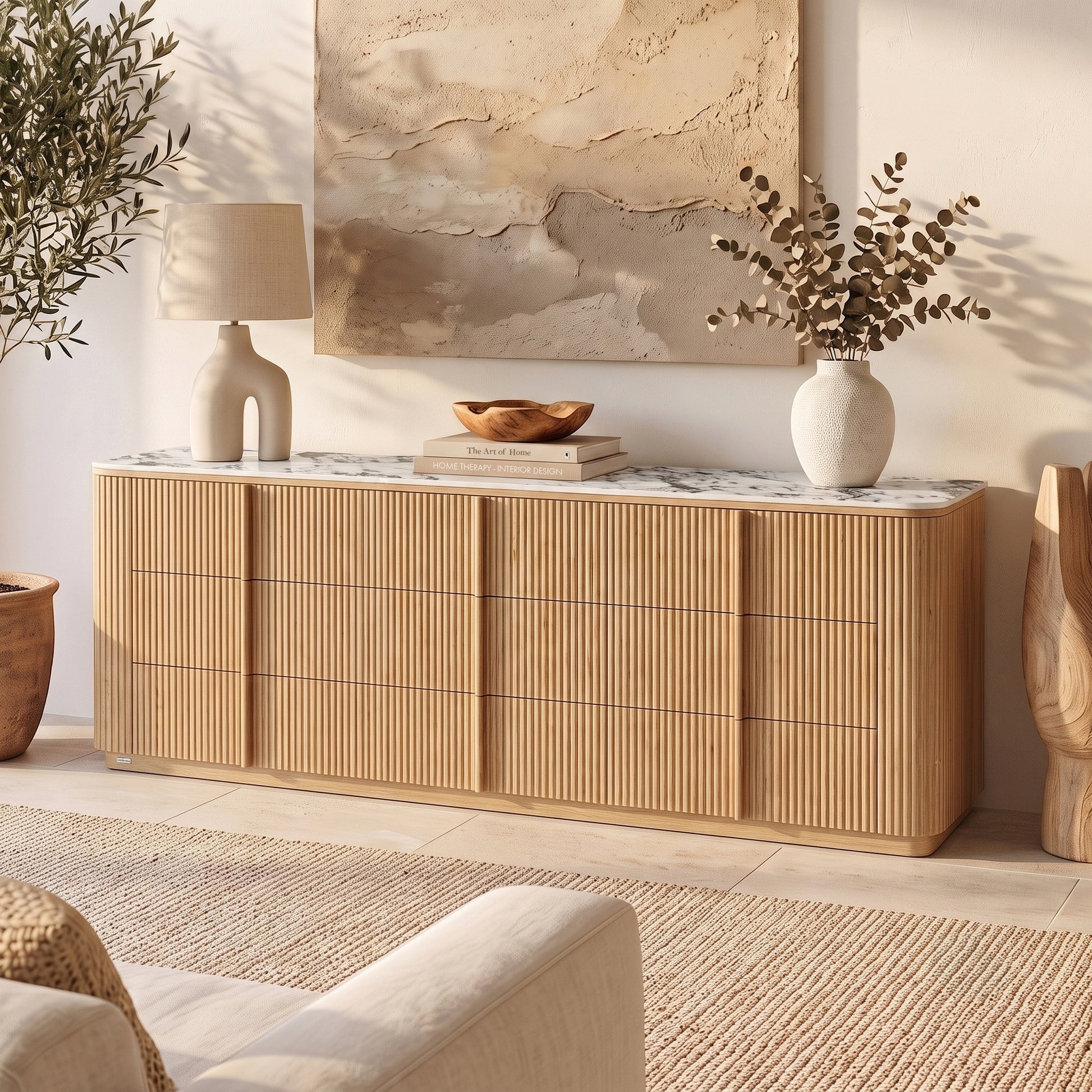 Natural fluted wood sideboard with white marble top and rounded corners in sunlit room