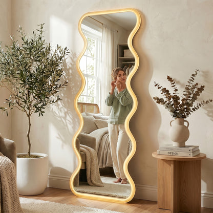 Davor 160cm Organic Waves Full Length LED Mirror in White, featuring a back-lit wavy frame. Reflects a woman adjusting earrings, enhancing the room's elegance with adjustable LED lighting for varied ambiance.