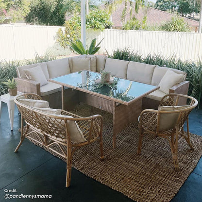Ballena 6 Seater Wicker Outdoor Dining Sofa Set – Beige/Light Beige displayed with cushioned wicker seating and a glass-topped table with a houseplant, set on a patio for stylish outdoor dining.