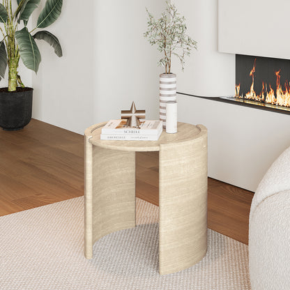 Behnaz 56cm Round Indoor/Outdoor Concrete Side Table with an arched base, suitable for displaying plants or books, stands on a floor inside a room near a wall and a fireplace.