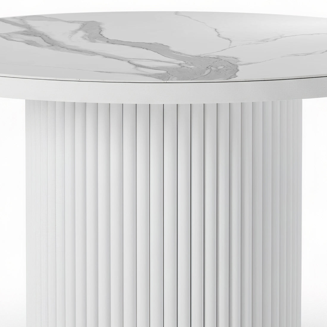 Close-up of a round dining table featuring a white stone top with grey marble veining and a matching white fluted pedestal base.