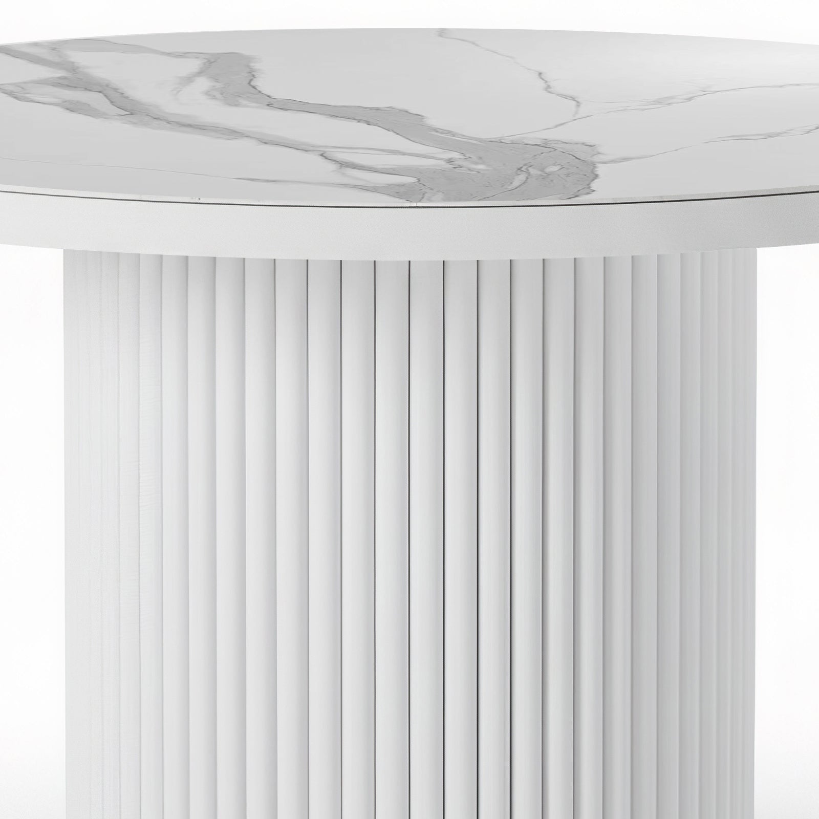 Close-up of a round dining table featuring a white stone top with grey marble veining and a matching white fluted pedestal base.
