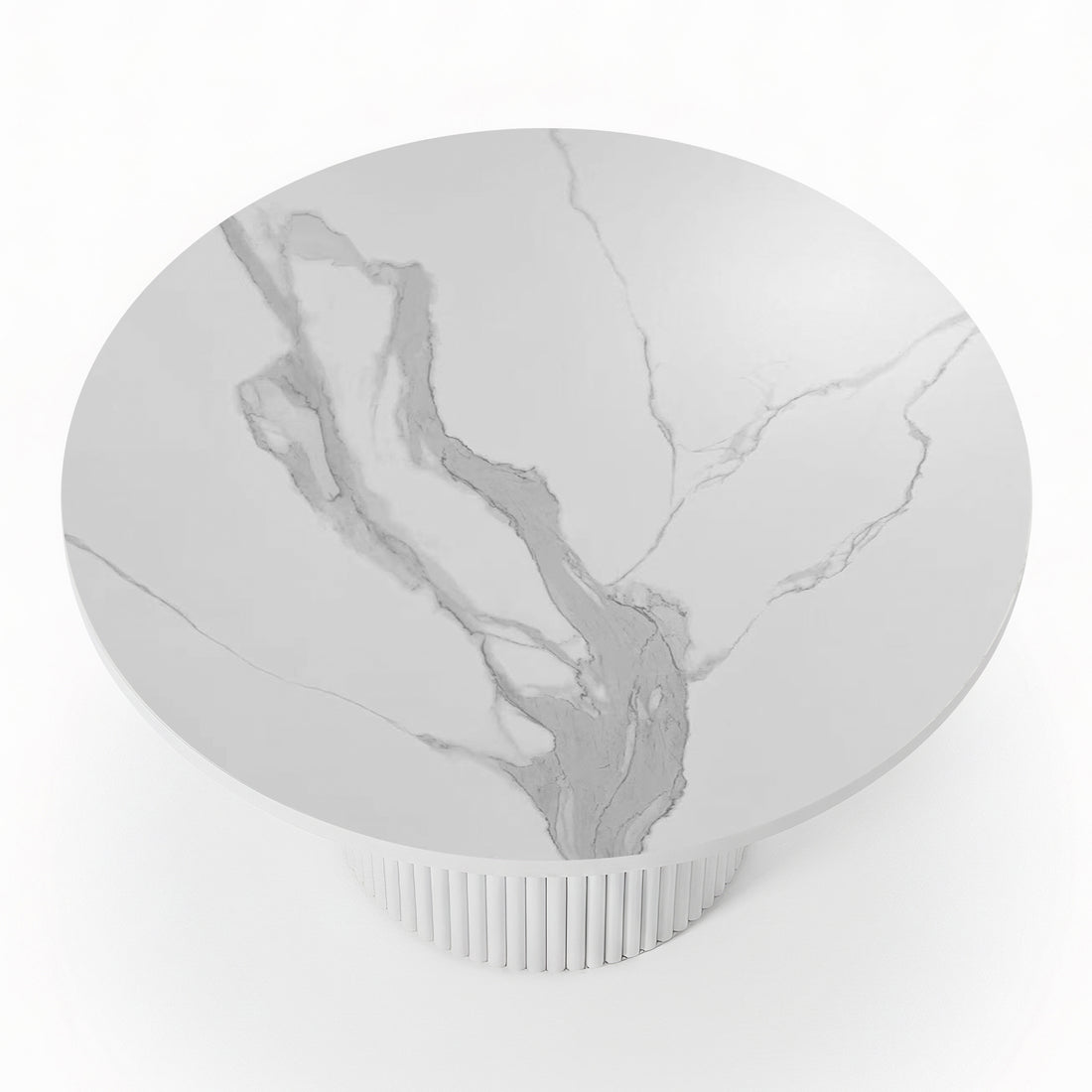 Close-up of a round dining table featuring a white stone top with grey marble veining and a white fluted pedestal base_2