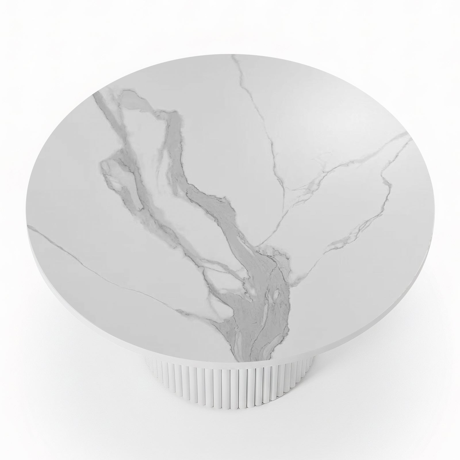 Close-up of a round dining table featuring a white stone top with grey marble veining and a white fluted pedestal base_2