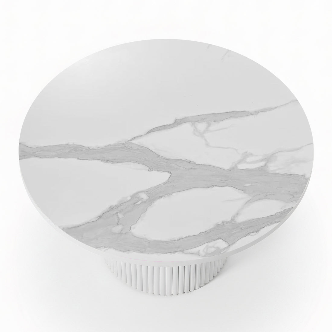 Close-up of a round dining table featuring a white stone top with grey marble veining and a white fluted pedestal base_3