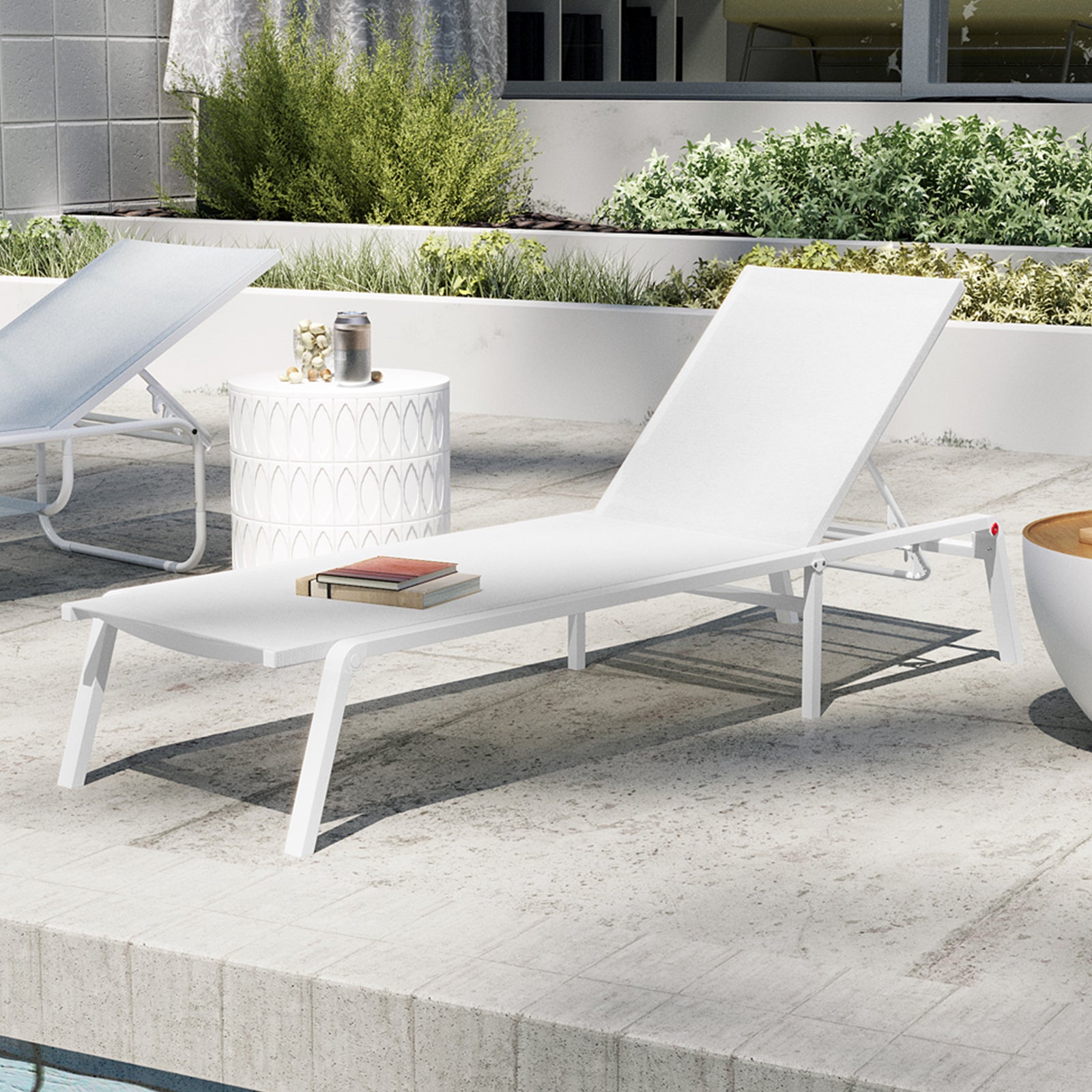 Jabari Textilene Aluminium Outdoor Sunbed in Cream White with adjustable backrest, white metal frame, and two stacked books. Nearby, a side table with tumbler and jar, set by a pool.