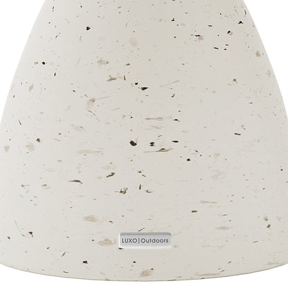 Detail shot of the Junia Terrazzo concrete side table's speckled surface and base, featuring the Luxo Outdoors tag